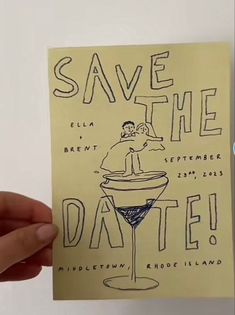 a hand holding up a piece of paper that says save the date