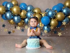 a baby sitting in front of a cake with the number one on it's top