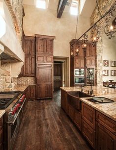 a large kitchen with wooden cabinets and marble counter tops