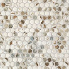 a white and brown mosaic tile pattern with circles on it's surface, as well as dots in the center