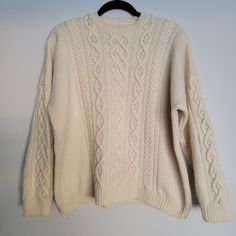 "Excellent Vintage Condition Women's Handknit Cable Knit Pullover Sweater with Fisherman's Rib Hem Cream color or off-white Yarn feels like wool or wool blend (heavy) No shrinkage (looks unworn), no visible stains (clean) No size indicated  Measurements are approximate (laying flat): Length: 23\" Shoulders: 27\" Chest (pit to pit): 24\" Hem: 42\" Sleeve length (shoulder to cuff): 16 1/2\" Arm hole (pit to pit): 19\"" Beige Knitted Crew Neck Sweater, Beige Crew Neck Knitted Sweater, Classic Cream Crew Neck Sweater, Off White Textured Knit Long Sleeve Sweater, Off White Long Sleeve Textured Knit Sweater, Casual Off-white Winter Sweater, Cream Knit Crew Neck Outerwear, Cream Crew Neck Knit Outerwear, Classic Cream Sweater For Fall