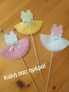 three paper fans with bows on them sitting on a wooden floor next to each other