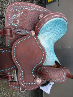 a close up of a brown and blue western style saddle with studs on it