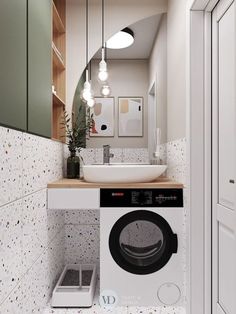 a washer and dryer in a small room with lights on above the sink