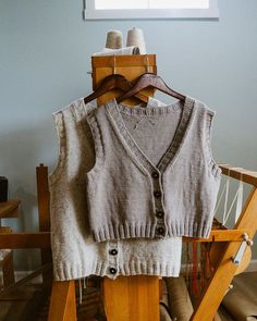 an old sweater vest is hanging on a wooden chair