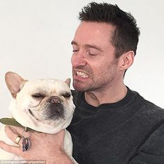 a man holding a small white dog in his arms and smiling at it's owner