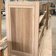 an unfinished wooden cabinet in a shop