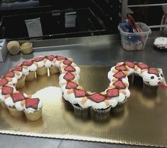 two cupcakes with white frosting and red decorations are on a metal tray