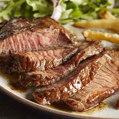 steak and french fries on a plate with lettuce, tomato wedges and salad