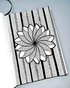 an open notebook with a flower drawn on the front and back cover in black and white