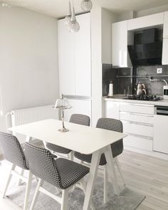 a white table and four chairs in a room