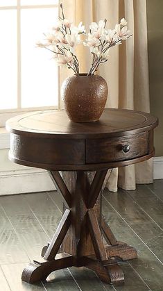 a vase with flowers sitting on top of a wooden table next to a window in a room