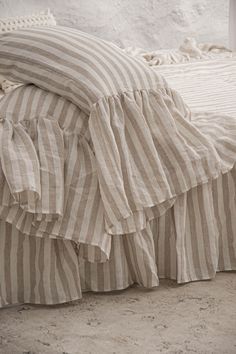 an unmade bed with ruffled bedspread and pillows