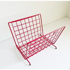 a red shopping cart sitting on top of a white floor