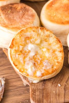 several baked goods sitting on a wooden cutting board next to garlic bread and sea salt