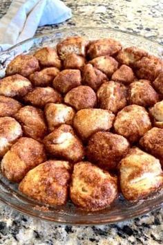 a glass dish filled with cinnamon rolls on top of a counter