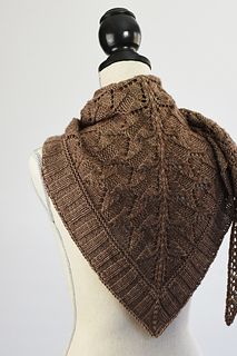 a brown knitted shawl on top of a mannequin's head