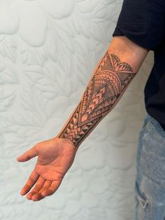 a man's arm with a tattoo on it and his hand in the air