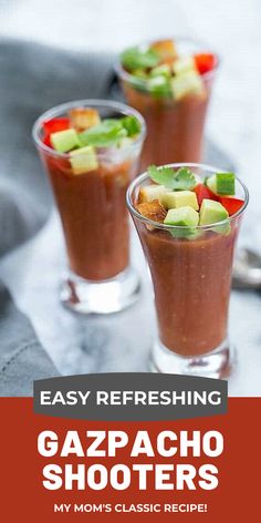 two glasses filled with gazpacho shooters on top of a table