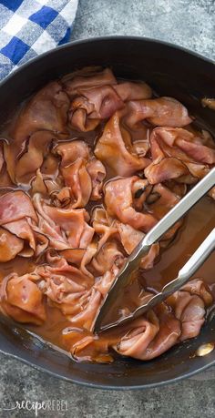 a pan filled with meat and sauce on top of a table