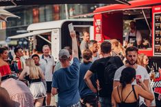 a crowd of people standing around a food truck