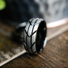 a black ring with an arrow pattern on it sitting on top of a wooden table