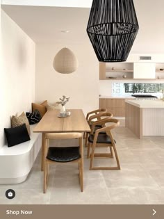 a dining room table with chairs and a bench in front of the kitchen counter top