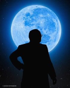 a man standing in front of the moon with his hands on his hips