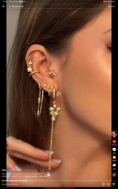 a woman wearing gold ear cuffs and piercings