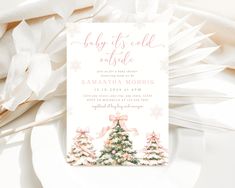 a baby it's cold outside christmas party card on a white plate with pink ribbon