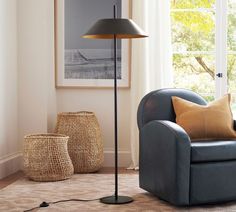 a living room scene with focus on the floor lamp and chair in the foreground