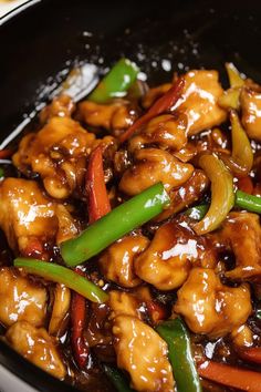 chicken and vegetables are in a wok with sauce