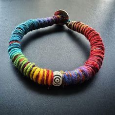 a multicolored beaded bracelet with a metal button on it's end