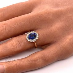 a woman's hand with a ring on it and a blue stone in the middle