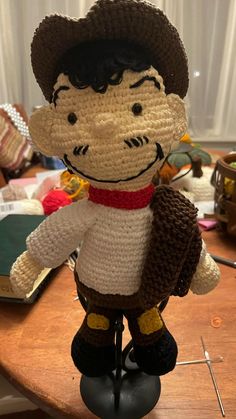 a crocheted toy with a cowboy hat and scarf on it's head