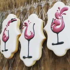 three decorated cookies sitting on top of a plastic tray next to each other in the shape of flamingos