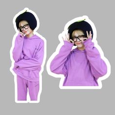 a young boy wearing glasses and a purple outfit is making the peace sign with his hands