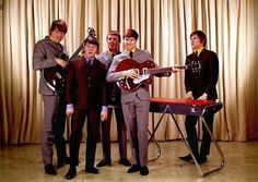 a group of young men standing next to each other with guitars in front of them