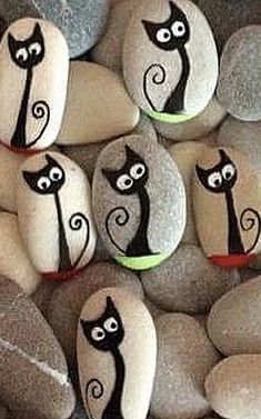 some rocks with black cats painted on them