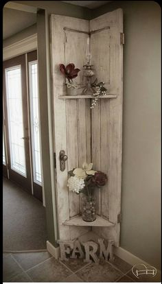 an old door is used as a shelf for vases and flowers in the entryway