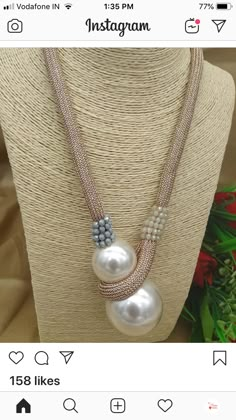 a necklace with pearls and beads hanging from it's side on a mannequin