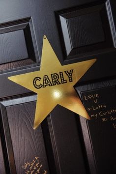 a gold star with the word cary written on it is attached to a black door