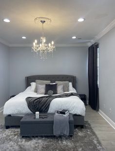 a bedroom with a large bed and chandelier