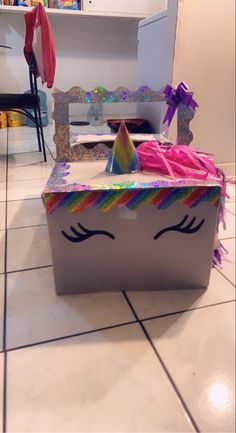 a box that has a unicorn face on it and is sitting on the floor in front of a counter