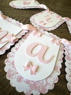 pink and white baby shower decorations on a wooden table with the letters g, n, o