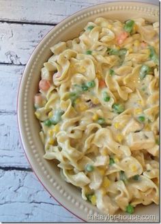 a bowl filled with pasta and peas on top of a table