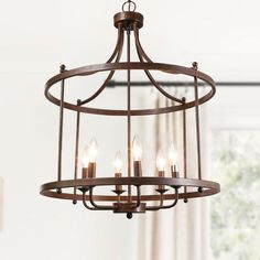 a chandelier hanging from a ceiling in a living room with white walls and windows