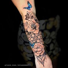 a woman's arm with flowers and a butterfly on it