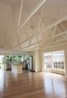 an empty kitchen and living room with wood floors