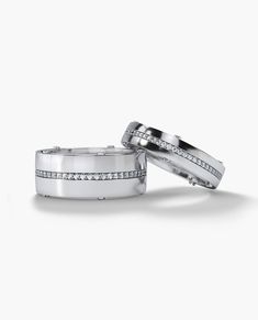 two white gold wedding bands with diamonds on each side, set in 18k white gold